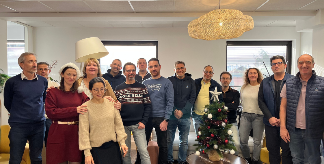Photo d'équipe autour d'un sapin décoré. 