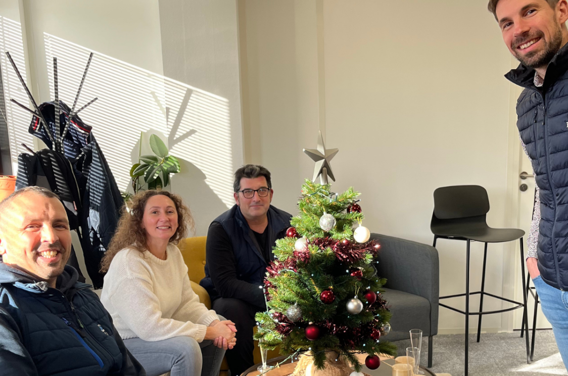 Photo d'équipe autour d'un sapin décoré. 